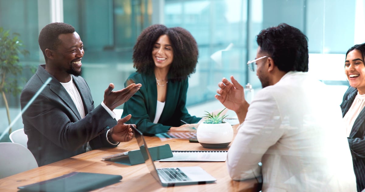 Black African business people laughing and collaborating in modern office meeting