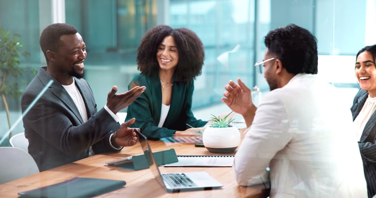 Black African business people laughing and collaborating in modern office meeting with laptops and financial planning